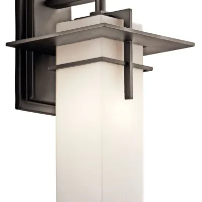 This 1 light wall lantern from the Caterham(TM) collection is both versatile and charming. The Satin Etched Glass shade rests beautifully against the rich Olde Bronze finish.